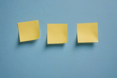 Yellow post it notes on a blue background. Minimal concept.の写真素材