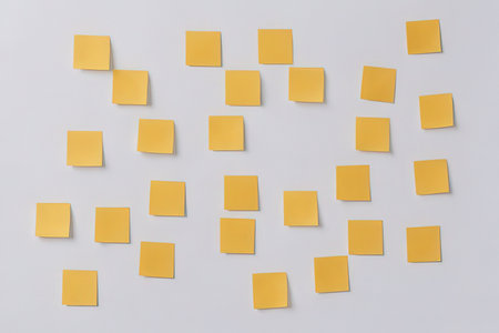 Yellow sticky notes on a white background. Post it to the wall.の写真素材