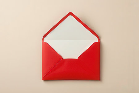 Red envelope with white paper on beige background. Top view.