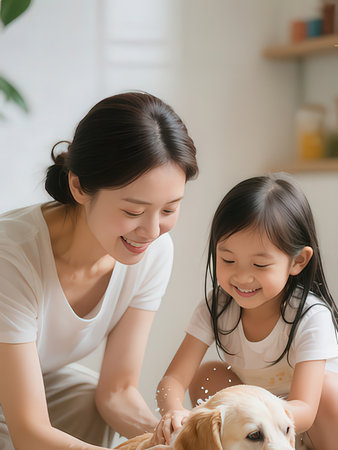 Happy asian family playing with dog at home. Mother and daughter spending time together.のeditorial素材