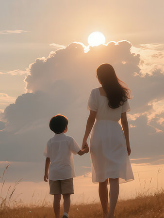 Silhouette of mother and son holding hands and looking at sunset
