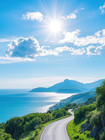 Asphalt road on the sea coast under blue sky with white cloudsの写真素材