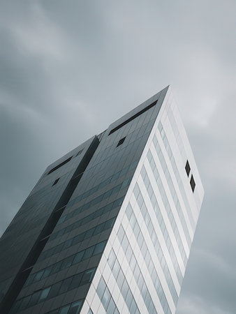 A low angle shot of a modern skyscraper under the cloudy sky