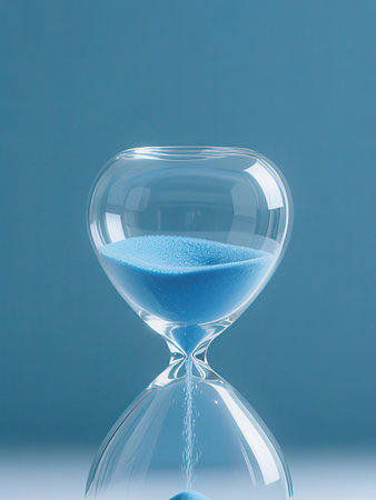 Hourglass with blue sand on a blue background. Time concept.