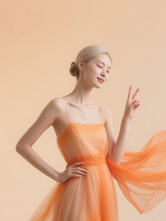 beautiful young woman in orange dress showing peace sign, isolated on beigeのeditorial素材