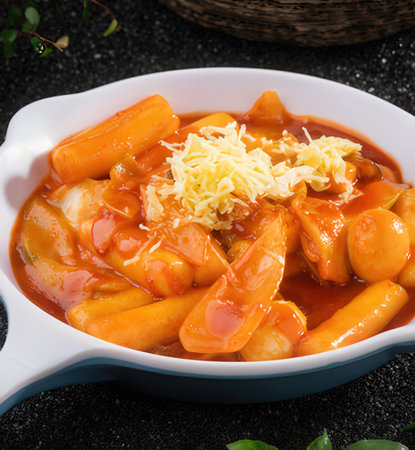 Sausage in tomato sauce with grated cheese in a ceramic dish