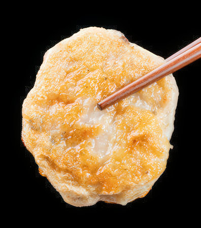 Fried dumpling with chopsticks isolated on black background.