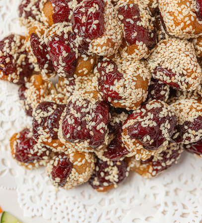 Dried fruits with sesame seeds on a white plate. Top view.