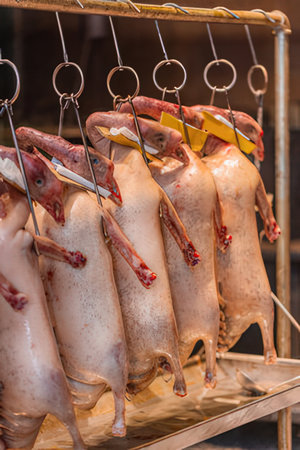 Fresh raw pig carcasses hanging on a shelf in a butcher shopのeditorial素材