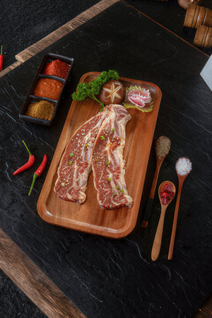 Raw T-bone steak on wooden cutting boardの写真素材