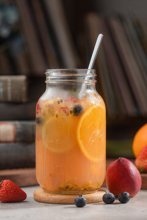 Detox drink with fruit and berries in a glass jar on a wooden tableの写真素材
