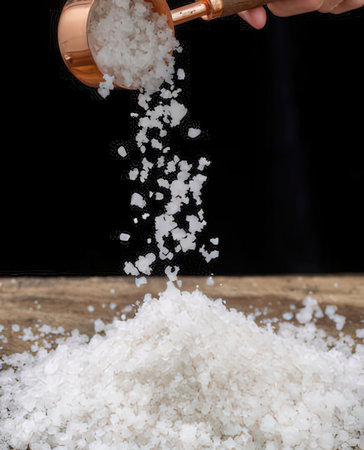 salt pouring from a sieve into a pile of white salt