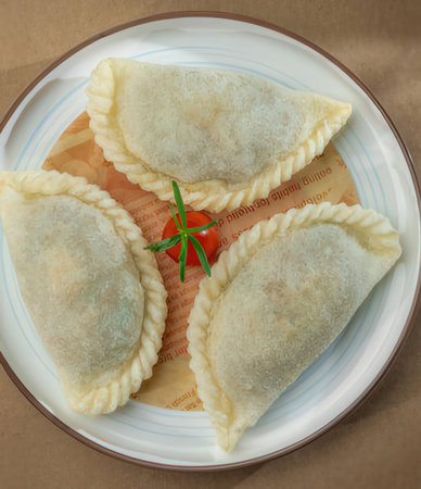 Fried dumplings stuffed with meat and vegetables on a plateの写真素材