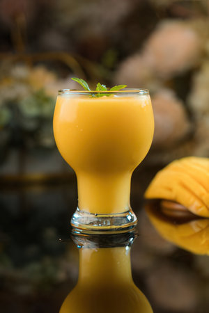 Tropical fruit smoothies with mango, pineapple and mint in glassの写真素材