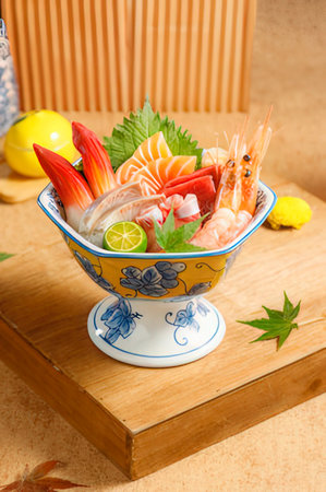 Japanese sashimi in bowl with chopsticks on wooden table.の写真素材