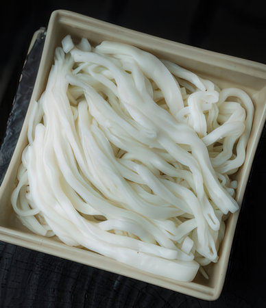 Japanese udon noodles in a bowl on black wooden table, selective focusの写真素材