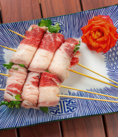 raw beef skewer on a plate over a wooden tableの写真素材
