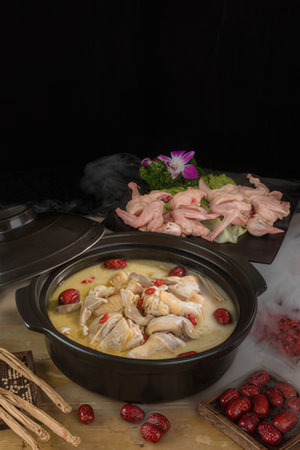 Chicken soup in a pot on a black background. Chinese cuisine.の写真素材