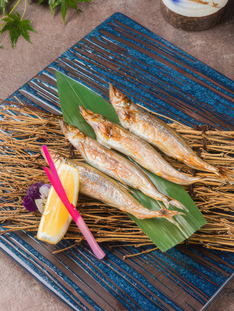 Fried mackerel with lemon and herbs on a plate.の写真素材