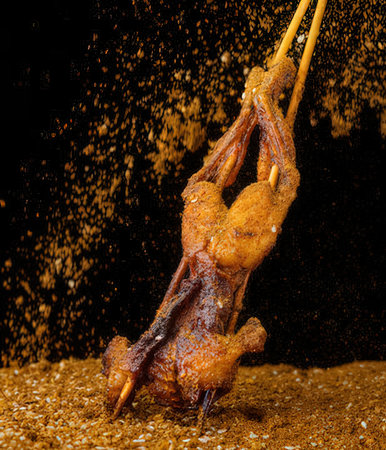 Grilled chicken on a black background with splashes of water.の写真素材