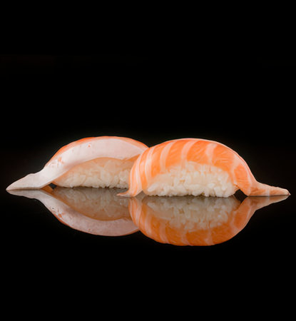 Sushi nigiri with salmon on a black background with reflection.の写真素材