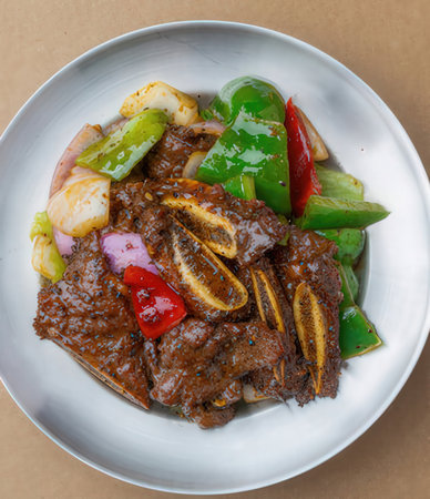 Malaysian dish of beef with vegetables on white plate.の写真素材