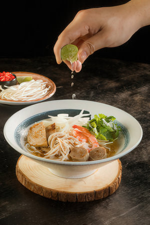 Pork noodle soup with rice vermicelli on black backgroundの写真素材