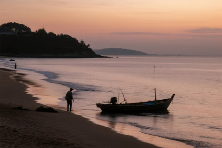 Fisherman and fishing boat on the beach at sunset, Thailandの素材