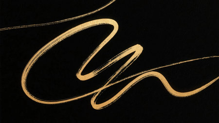 calligraphic design - letter n on a black background with gold paintの素材