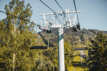 Ski lift on the background of the forest and blue sky.