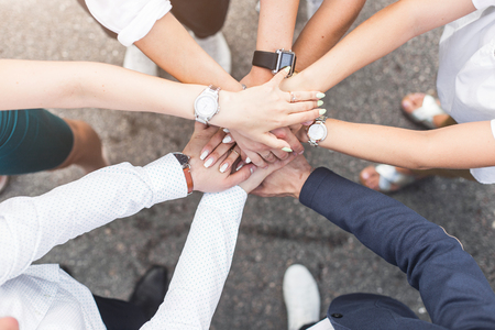 business, people and teamwork concept - smiling group of businesspeople standing in circle and putting hands on top of each otherの写真素材