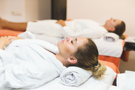 Two cute young women enjoying during a skin care treatment at a spa. massage and beauty treatments in the beauty salonの写真素材