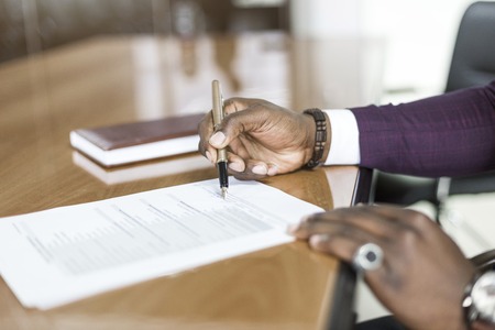 African american man signing contract, black man hand putting signature on official document,...