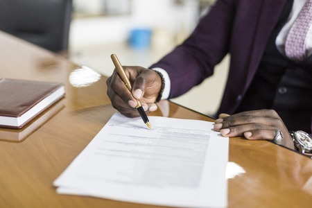 African american man signing contract, black man hand putting signature on official document,...