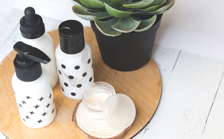 Beauty flat lay with cosmetic bottles, jar of face cream, succulent leaves and saw cut wood. Top view, minimalism, flatlayの写真素材