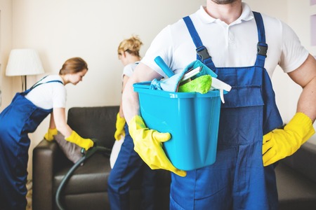 Cleaning service with professional equipment during work. professional kitchenette cleaning, sofa dry cleaning, window and floor washing. man and women in uniform, overalls and rubber glovesの写真素材