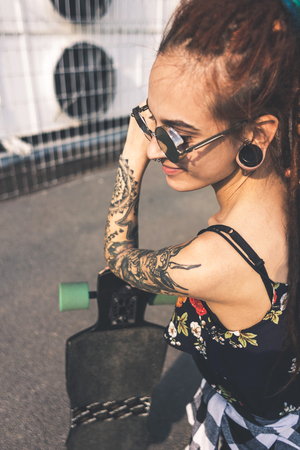 young girl with tattoo and dreadlocks on urban industrial backgroundの写真素材