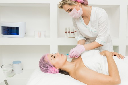 Young woman getting cosmetic injection in beauty clinicの写真素材