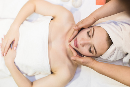beautiful girl enjoys face massage in spa salon. Procedures for beauty and rejuvenation. Thai massageの写真素材