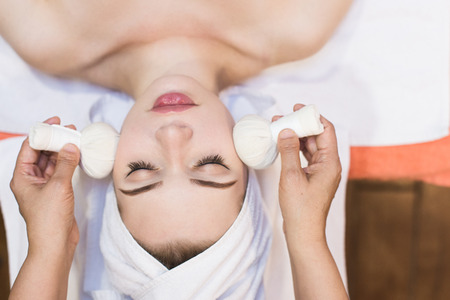 beautiful girl enjoys face massage in spa salon. Procedures for beauty and rejuvenation. Thai massageの写真素材