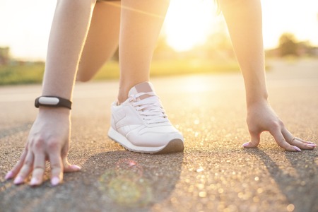 young woman runner warming up before run on city. the girl starts to run, her legs close-up. free...