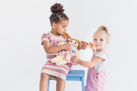 Two little girls playing on a white backgroundの写真素材