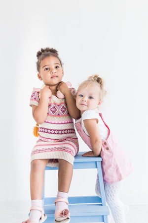 Two little girls playing on a white backgroundの写真素材