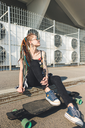 young girl with tattoo and dreadlocks on urban industrial backgroundの写真素材