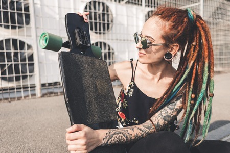 young girl with tattoo and dreadlocks on urban industrial backgroundの写真素材