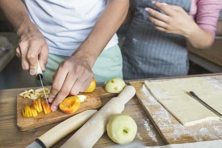 happy family is preparing a pie in the kitchen at home. concept of happy family and home cozinessの写真素材