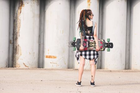 UFA, RUSSIA - September 12, 2018 Editorial photo of young girl with a longboard on the background of concrete structureのeditorial素材