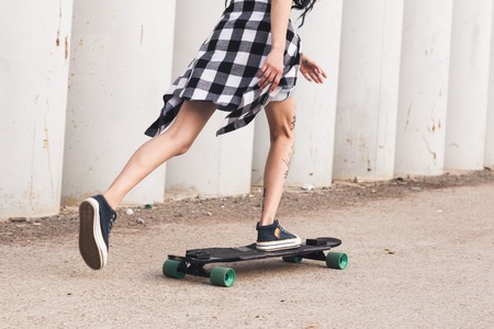 young girl with tattoo rides on a longboardの写真素材