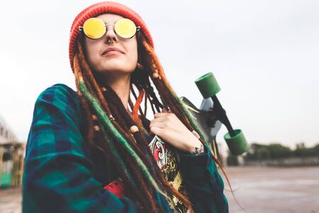 UFA, RUSSIA - September 12, 2018 Editorial photo of young girl in sunglasses and a hat stands with a longboard against the skyのeditorial素材