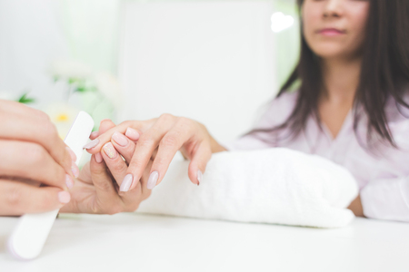 Young woman getting manicure in beauty salonの写真素材